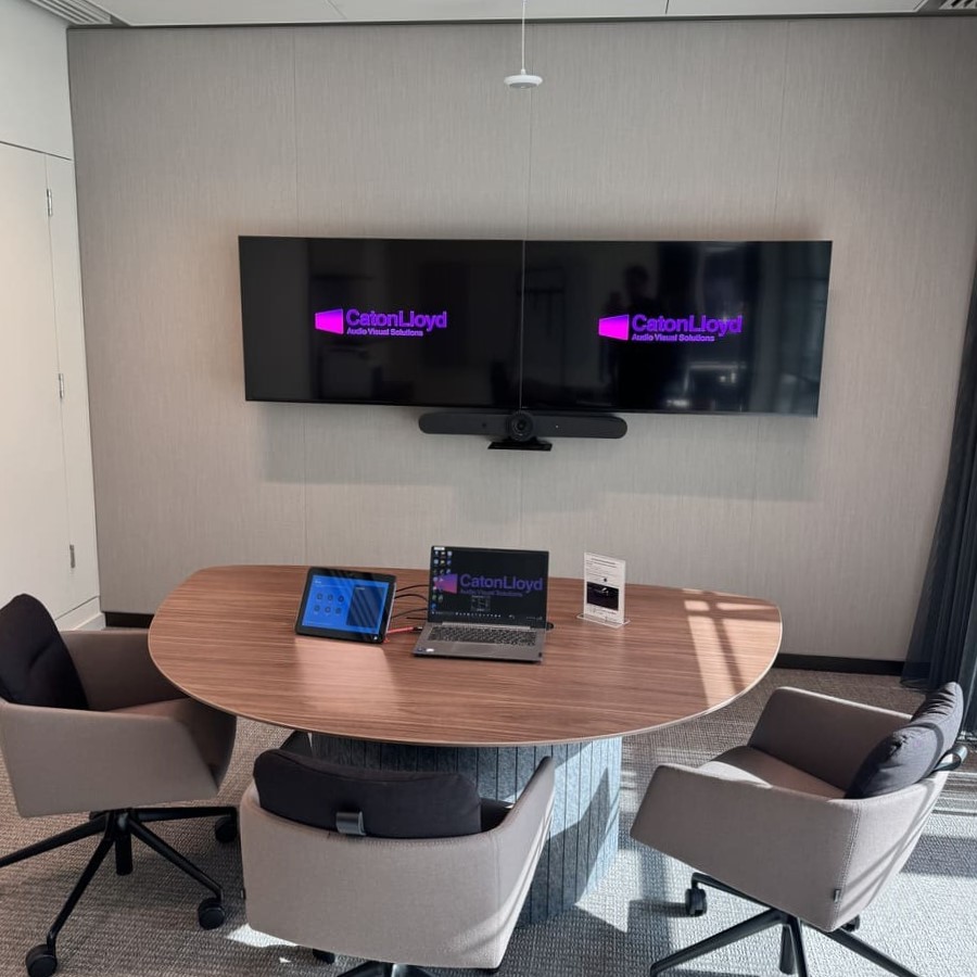 Small meeting room with twin screens, a user friendly control interface and ceiling mounted microphone in CoStar Groups London office