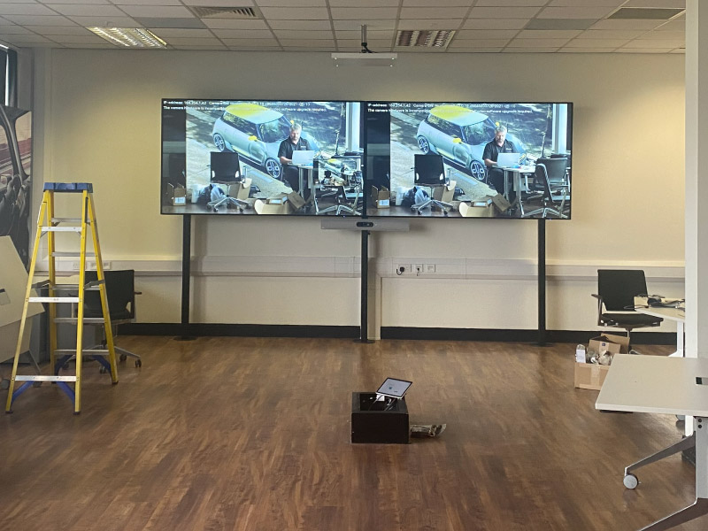Dual floor-mounted display screens installed inside of conference room by CatonLloyd.